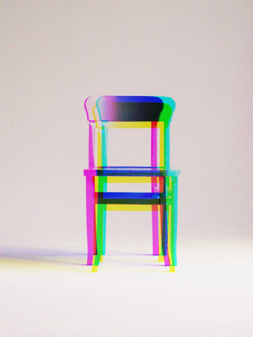 wooden chair with prism effect against a plain background