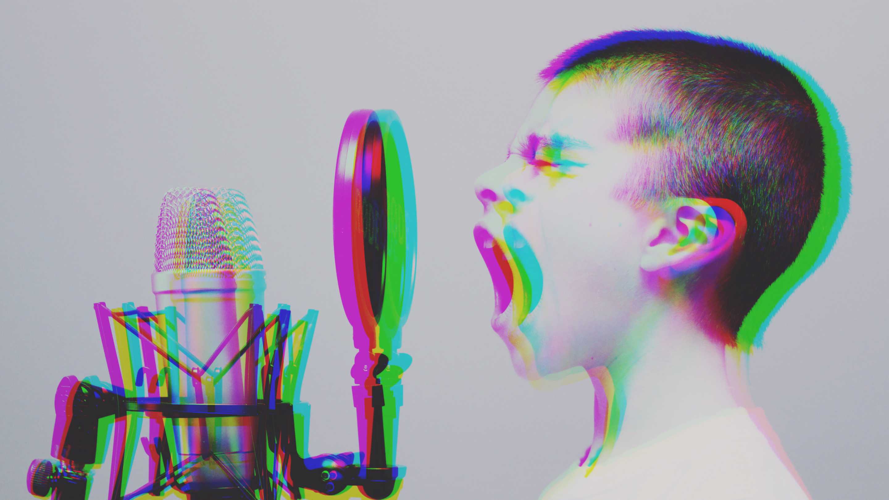 Glitched picture of shaven headed boy shouting into microphone with pop screen